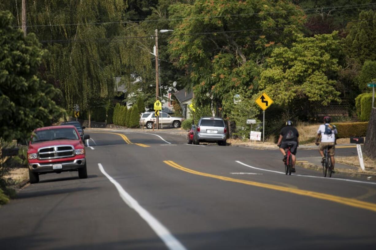 Luke Youngblood of Camas, left, and Devin Garrett of Washougal, right, make their way down the hill on McLoughlin Boulevard on Friday. “Going uphill sucks,” Youngblood said. “You’re out in the middle of the lane.” The city is proposing to make East McLoughlin safer for cyclists and are discussing the possibility of removing on-street parking to build a double bike lane.