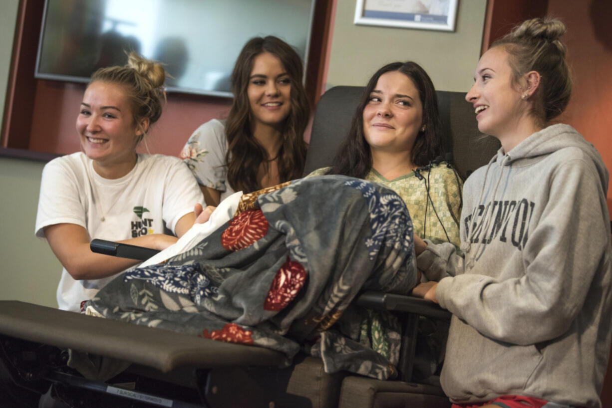 Jordan Holgerson, in chair, is surrounded by friends and family while joking with the media about her injuries at PeaceHealth Southwest Medical. Surrounding Holgerson are, from left, friend Masey Tucker, sister Kaytlin Holgerson and friend Taylor Lavigne.