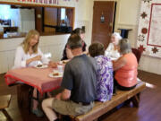 Battle Ground: Members of the Venersborg Historic Preservation Society and the Frank L. and Arlene G. Price Foundation enjoy some cake while celebrating an $11,000 grant from the foundation to fix up the Venersborg Schoolhouse roof. Hanging on the wall next to their table is a quilt the society will raffle to support upkeep of the site.