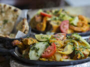 Tandoori chicken, front, is served at Chutneys Indian Restaurant and Grocery Store in east Vancouver.