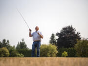 Mike McCoy, owner of Snake Brand Products, demonstrates fly-casting techniques on the lawn outside his workshop. McCoy makes a patented line guide for fly rods that enables fishers to cast farther and more accurately.