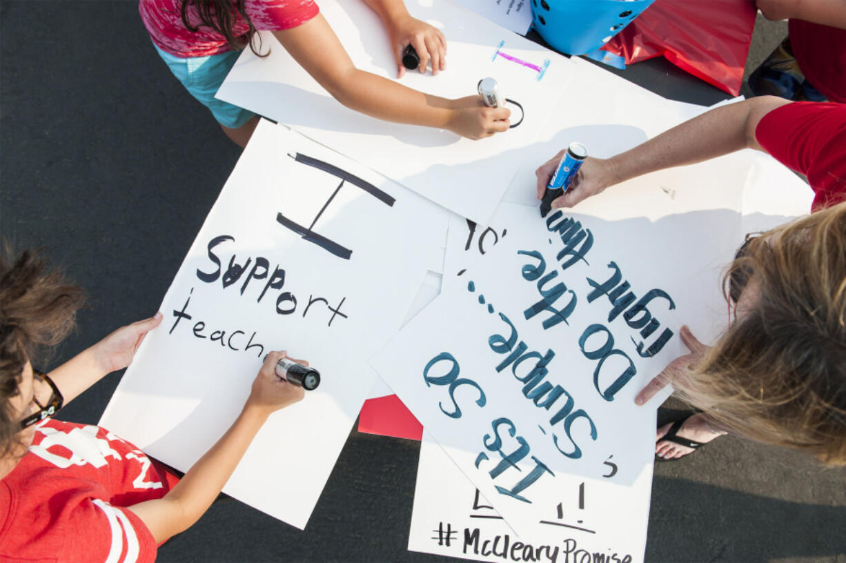 Evergreen Education Association union members and supporters make signs at a meeting on Aug. 14. On Tuesday, teachers in Washougal and Hockinson voted to approve strikes if new deals aren’t reached by the start of the school year. Teachers in Evergreen, along with Battle Ground, will vote on potential strikes later this week.