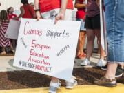 A supporter of the Evergreen Education Association holds a protest sign while attending Evergreen Public School Board meeting on Tuesday evening, Aug. 14, 2018.