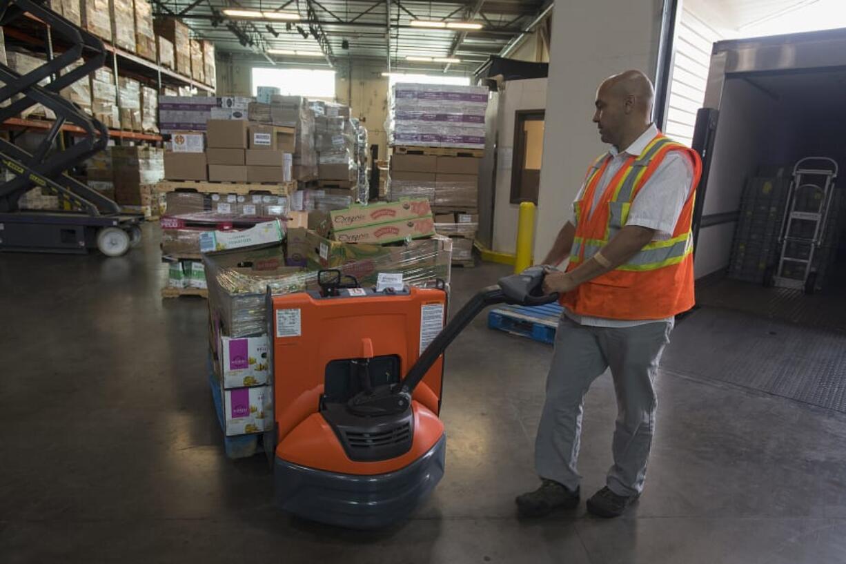 Glen Jones, food and warehouse manager, unloads donated food from Costco from the delivery truck Thursday afternoon at the Clark County Food Bank. The recovery program, known as Fresh Alliance, is a nationally recognized food bank program that gathers food grocery stores no longer want and distributes it to local food banks. Two local Costcos recently began participating in the program.