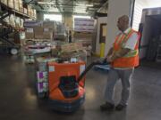 Glen Jones, food and warehouse manager, unloads donated food from Costco from the delivery truck Thursday afternoon at the Clark County Food Bank. The recovery program, known as Fresh Alliance, is a nationally recognized food bank program that gathers food grocery stores no longer want and distributes it to local food banks. Two local Costcos recently began participating in the program.