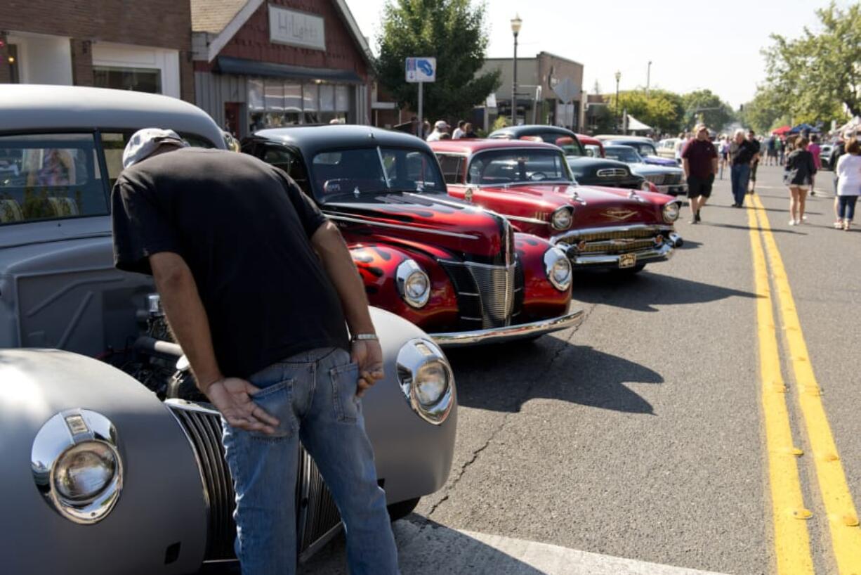 A man peeks under the hood of a classic car at the Slo Poks Show & Shine car show Saturday along Main Street in Uptown Village. Onlookers were asked to look but not touch the vehicles.