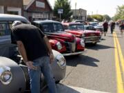 A man peeks under the hood of a classic car at the Slo Poks Show & Shine car show Saturday along Main Street in Uptown Village. Onlookers were asked to look but not touch the vehicles.