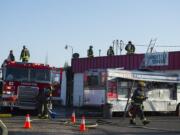 Firefighters work at the scene of a blaze at Vick's Market at 4903 East Fourth Plain Boulevard on Friday evening, Aug. 17, 2018. No injuries were reported in the fire, which was reported to have started in a room in the back of the store and then spread to the attic.