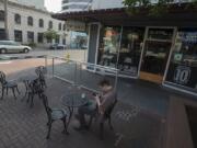 Vancouver resident Sheldon Gustafson relaxes with an after-work drink in the outdoor seating area at Top Shelf Martinis on Main. Negotiations led the restaurant to change its patio to satisfy state and local regulations, setting a precedent for other businesses statewide.