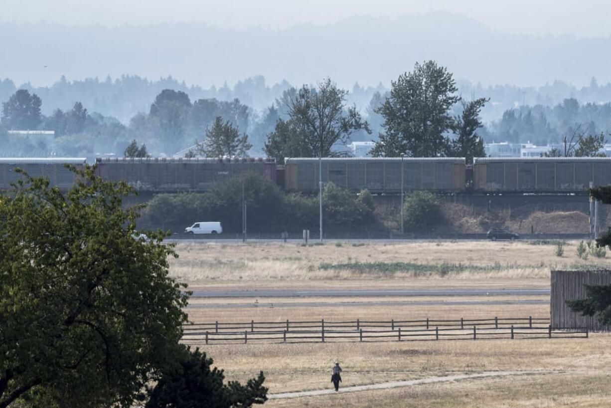 A pedestrian walks near the Fort Vancouver Stockades under lingering smoke on Tuesday.