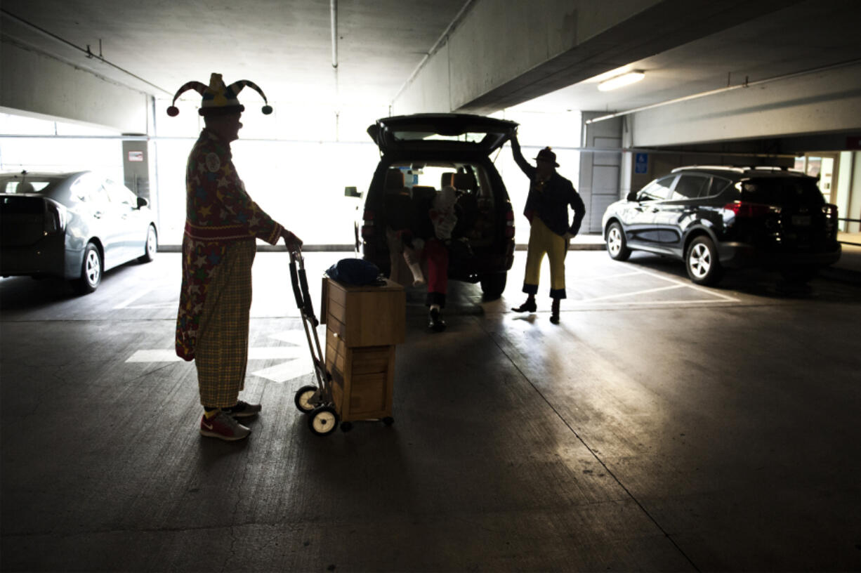 Stretch, played by Ray Zimmerman of Battle Ground, left, and Bumps, played by Dave Bryant of Salmon Creek, collect their props in the parking garage of the Shriners Hospital for Children in Portland before performing at a hospital party. The clowns visit the hospital each month for their performances.