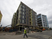 Construction continues along The Waterfront Vancouver as the Rediviva apartment complex, center, takes shape Friday morning. Although the complex isn’t ready for tenants yet, about 10 percent of its units have been pre-leased.