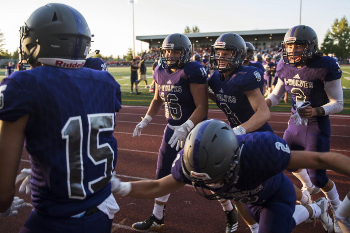 Heritage players celebrate an interception by Orlando Patino-Gonzalez (15) that sealed victory against Evergreen in the fourth quarter at McKenzie Stadium on Friday night, Aug. 31, 2018.