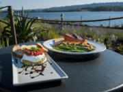 The Goat Cheese Torta, left, and the Potlatch Cedar Plank Salmon are seen here on the riverside patio at the Kalama McMenamins on Monday night, Aug. 27, 2018.