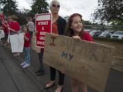 Taryn McCauley, second from right, and her daughter, Isabel, 11, right, join concerned parents and students outside the Jim Parsley Center while showing support for local teachers amidst contract negotiations Monday afternoon, Aug. 27, 2018.