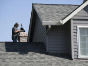 Dan Dilley, a chimney sweeper and owner of “A” Your Town Chimney, checks a chimney atop a customer’s home Tuesday in Camas. He has been sweeping chimneys for more than 30 years and has owned his Washougal business since 1996.