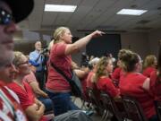 Katie Scot of Vancouver shouts out to the board as they call for a motion to move the meeting into another location during the Vancouver Public Schools board meeting on Tuesday. Scot's son attends Harney Elementary School, and Scot came to the meeting to support the teachers.