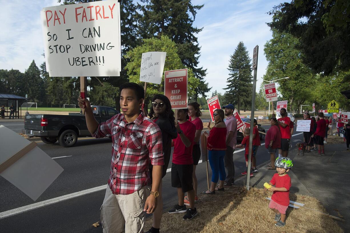 Hudson's Bay High School math teacher Tony Ho, in plaid, greets motorists with fellow strikers outside the school Wednesday morning, Aug. 29, 2018. Ho said he drives for Uber on Friday and Saturday nights to help make ends meet.