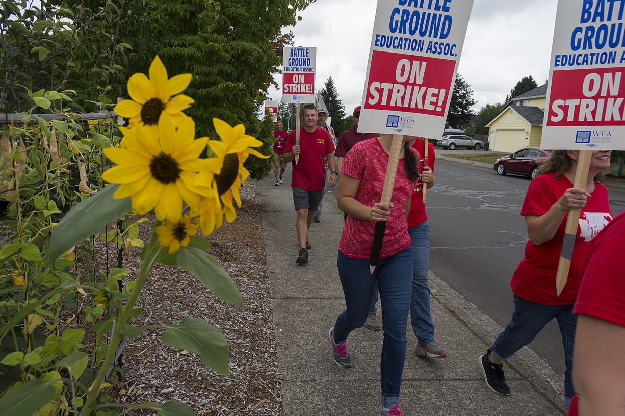 Teachers and supporters march through the neighborhood surrounding Captain Strong Primary School while picketing in Battle Ground on Thursday morning, Aug. 30, 2018.