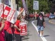 Community activist Anthony Licerio walks the picket line in support of rallying teachers in front of the Vancouver Public Schools' Administration Building on Friday afternoon.