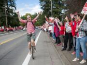 Tj Carlyson, math teacher at iTech Preparatory, cheers while riding his unicycle past a crowd of teachers In front of the Vancouver Public Schools' Administration Building on Friday afternoon, Aug. 31, 2018.