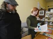 Leah Jackson, right, peruses contributions to a community art exhibit at Angst Gallery with Christopher Luna, a Vancouver poet and artist who works with her at the downtown Vancouver gallery.