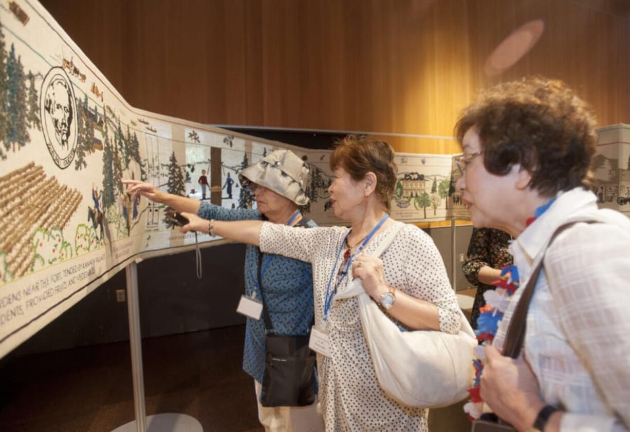 Japanese visitors examine the 108-foot-long Fort Vancouver Tapestry during a recent exhibition. The tapestry is displayed on special occasions — like this week’s Vancouver Chautauqua.