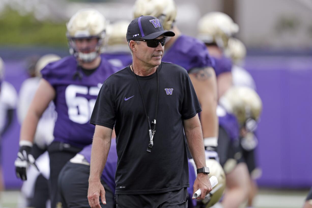 Washington head coach Chris Petersen walks on the field during a team football practice Friday, Aug. 3, 2018, in Seattle.