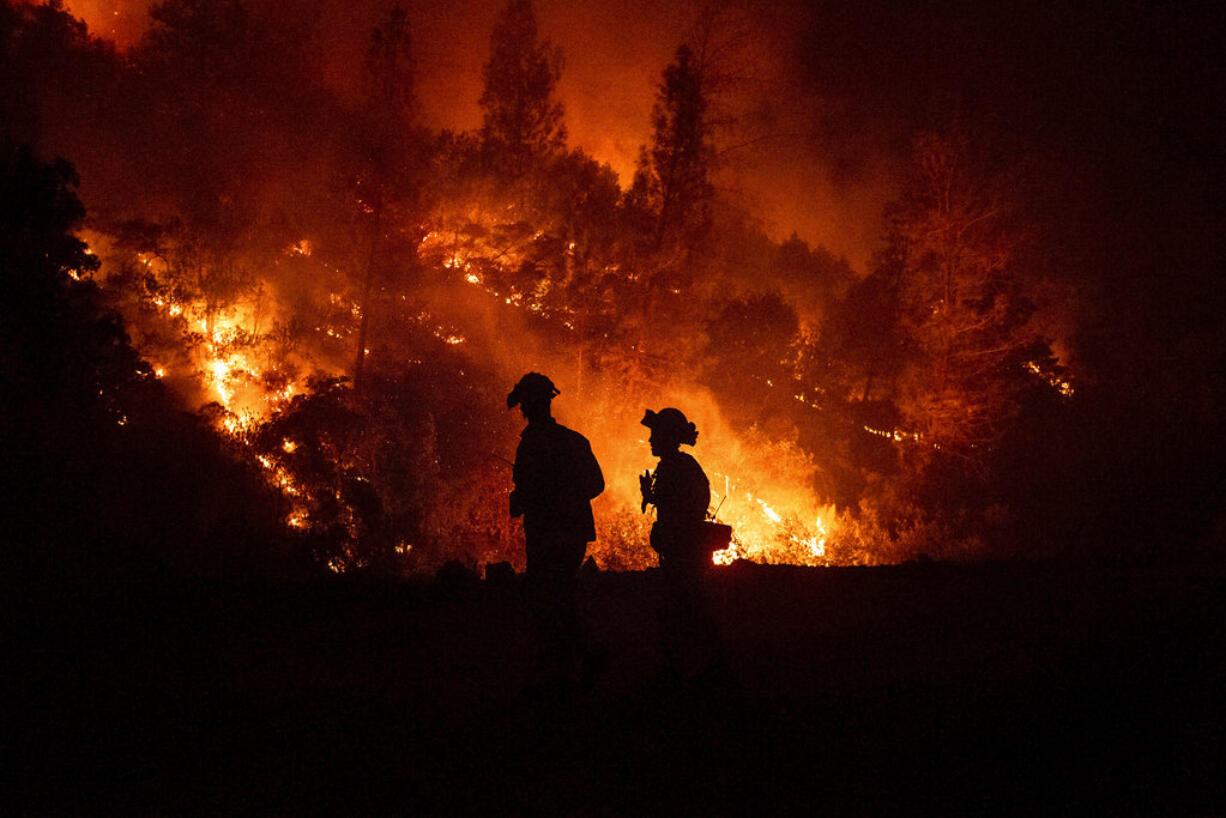 Firefighters monitor a backfire while battling the Ranch Fire, part of the Mendocino Complex Fire, on Tuesday, Aug. 7, 2018, near Ladoga, Calif.