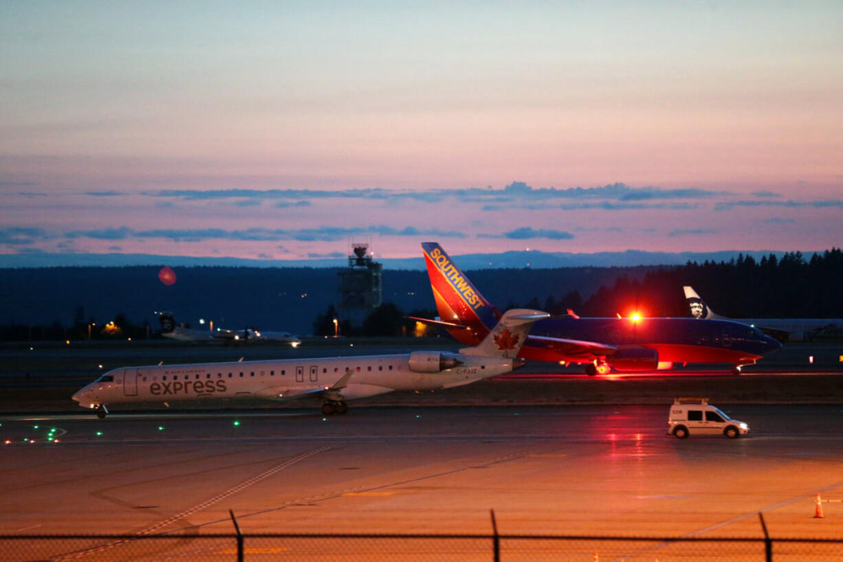 Planes sit on the tarmac at Sea-Tac International Airport after service was halted after an Alaska Airlines plane was stolen Friday, Aug. 10, 2018, in Wash. An airline mechanic stole an Alaska Airlines plane without any passengers and took off from Sea-Tac International Airport in Washington state on Friday night before crashing near Ketron Island, officials said.