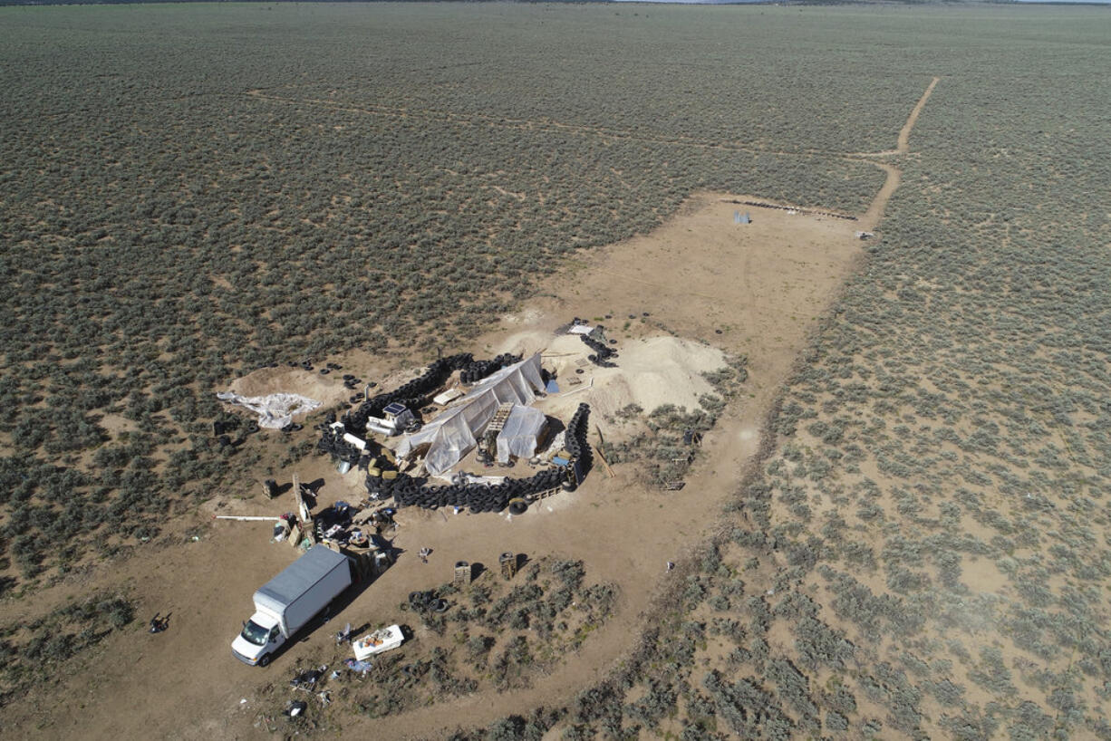 FILE - In this Friday, Aug. 10, 2018 file photo aerial view of a makeshift compound is seen in the desert area of Amalia, N.M. Prosecutors seeking to keep two men and three women jailed on child-abuse charges in northern New Mexico now say they seized a document entitled "Phases of a Terrorist Attack" at the filthy desert compound where 11 children and a dead boy were found. In a court filing Friday, Aug.