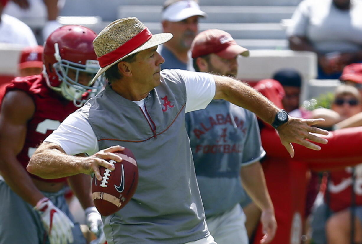 Alabama head coach Nick Saban throws a pass during a NCAA college football practice, Saturday, Aug. 4, 2018, in Tuscaloosa, Ala.