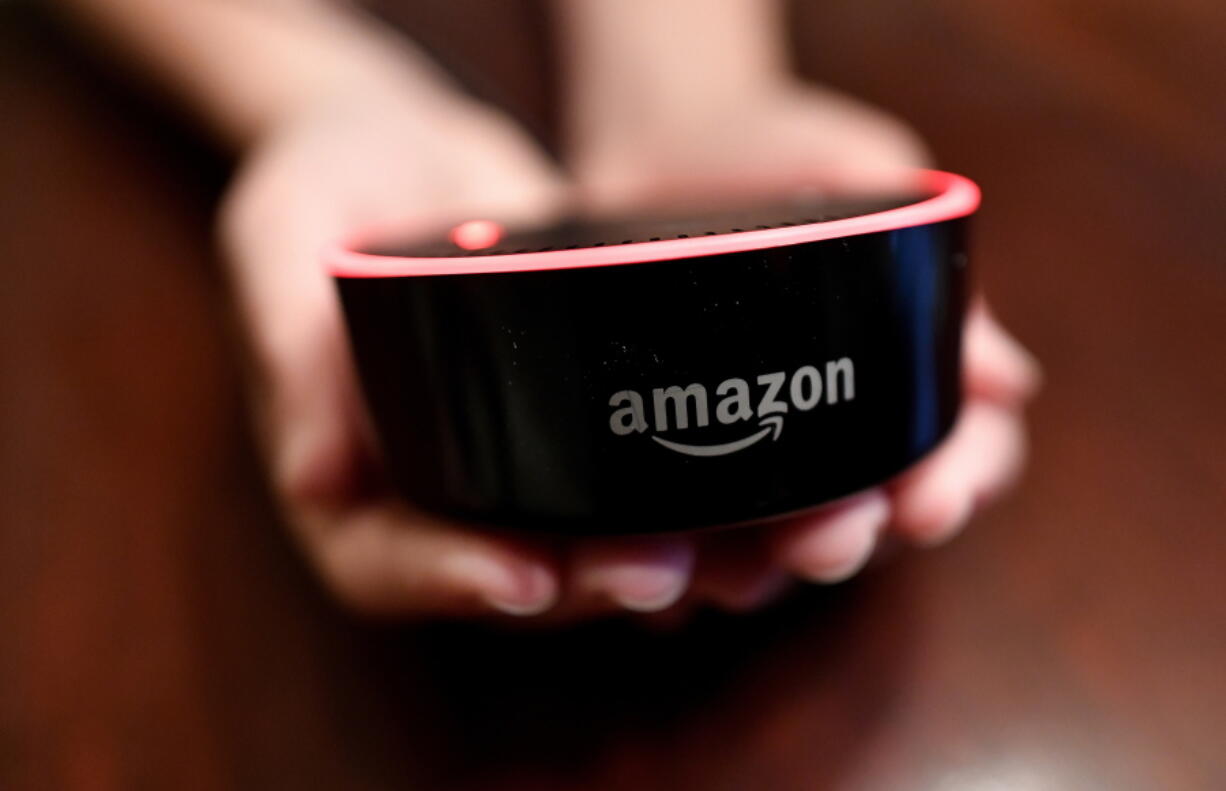 In this Thursday, Aug. 16, 2018, photo a child holds his Amazon Echo Dot in Kennesaw, Ga. Amazon updated its voice assistant with a feature that can make Alexa more kid-friendly. When the FreeTime feature is activated, Alexa answers certain questions differently.