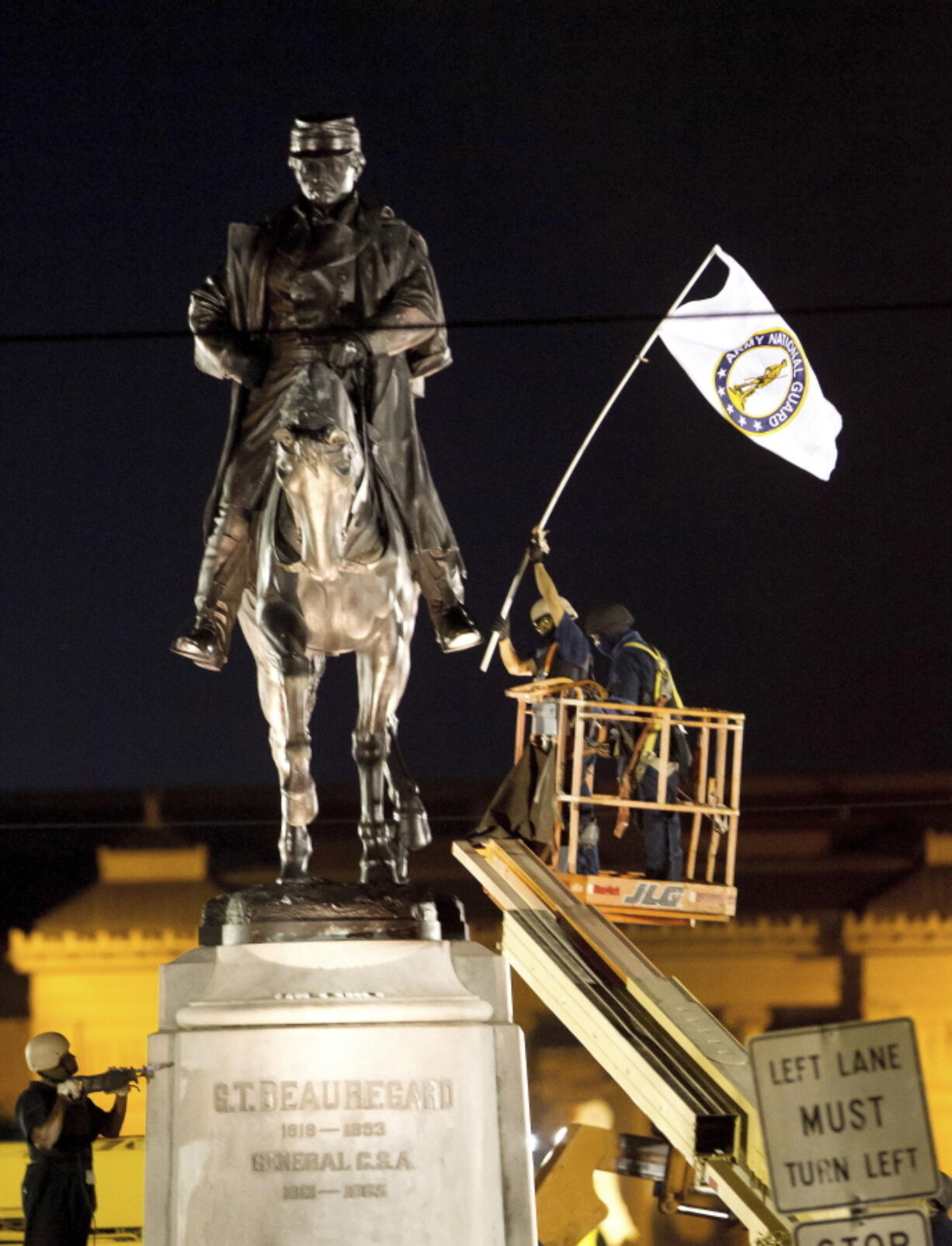 A worker in protective gear takes down an Army National Guard flag from the statue of Confederate General P.G.T. Beauregard during the statue’s removal from the entrance to City Park in New Orleans. The Louisiana lieutenant governor’s office says a time capsule has been found at the site where workers recently removed the pedestal that once carried the statue. The capsule will be opened Friday, Aug. 3, 2018.