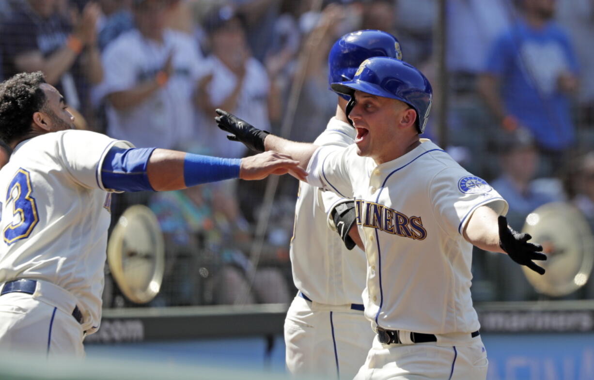 Seattle Mariners’ Kyle Seager, right, runs into the arms of Nelson Cruz after Seager’s home run against the Toronto Blue Jays in the seventh inning of a baseball game Sunday, Aug. 5, 2018, in Seattle.