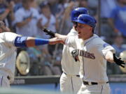 Seattle Mariners’ Kyle Seager, right, runs into the arms of Nelson Cruz after Seager’s home run against the Toronto Blue Jays in the seventh inning of a baseball game Sunday, Aug. 5, 2018, in Seattle.