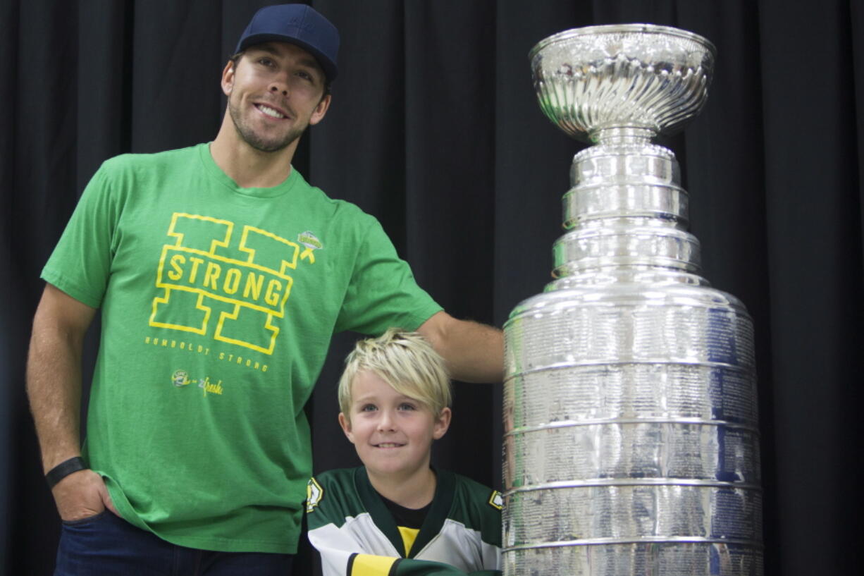 Washington Capitals NHL hockey left wing Chandler Stephenson and a young fan pose with the Stanley Cup during a Humboldt Hockey Day event in Humboldt, Saskatchewan, Friday, Aug. 24, 2018.