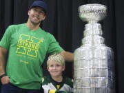 Washington Capitals NHL hockey left wing Chandler Stephenson and a young fan pose with the Stanley Cup during a Humboldt Hockey Day event in Humboldt, Saskatchewan, Friday, Aug. 24, 2018.