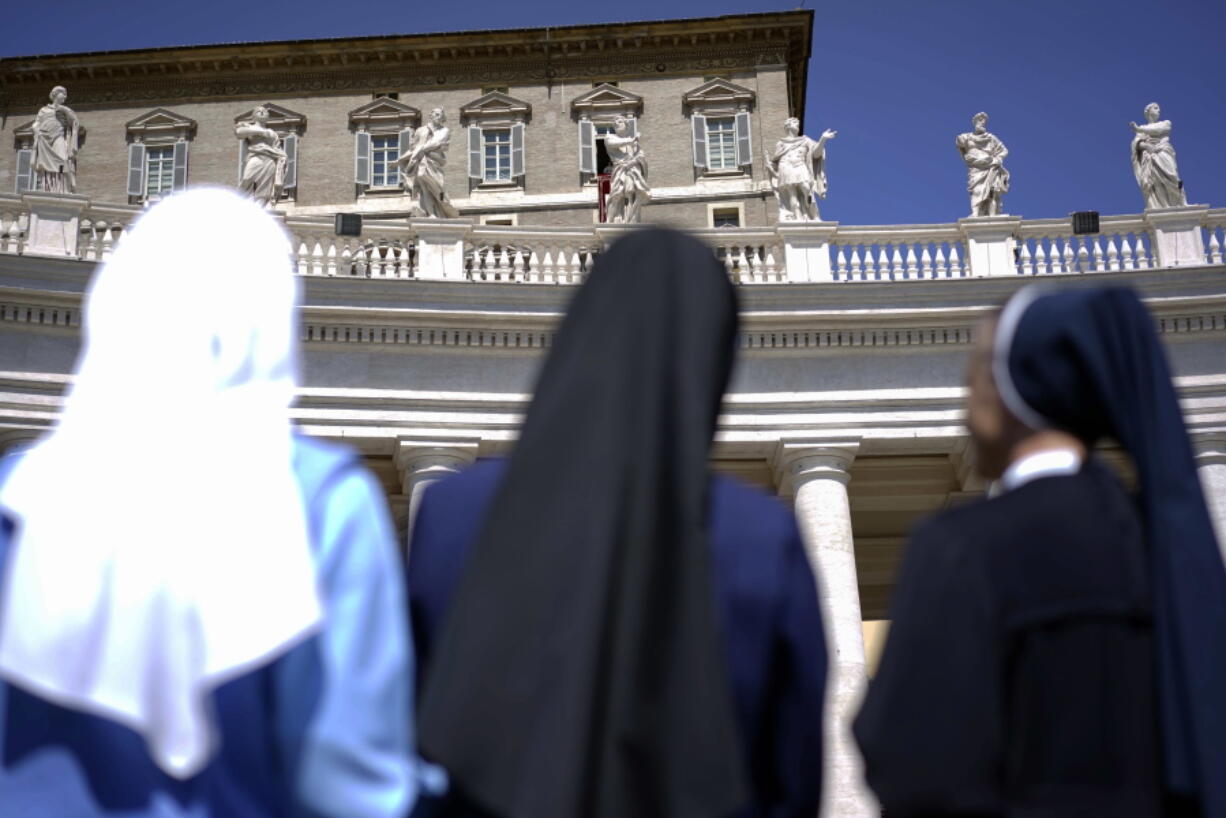 Nuns look up at Pope Francis delivering his blessing during the Regina Coeli prayer he celebrated from the window of his studio overlooking St. Peter’s Square, at the Vatican. Advocates of women’s ordination as Roman Catholic priests are citing the church’s unfolding sex abuse scandals in mid-2018 as powerful arguments for their cause, while acknowledging, as they do so, the high unlikelihood of achieving their goal any time soon.