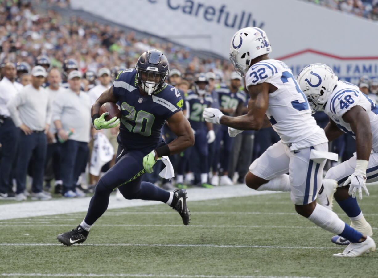 Seattle Seahawks running back Rashaad Penny (20) rushes past Indianapolis Colts defensive back T.J. Green (32) during the first half of an NFL football preseason game, Thursday, Aug. 9, 2018, in Seattle.