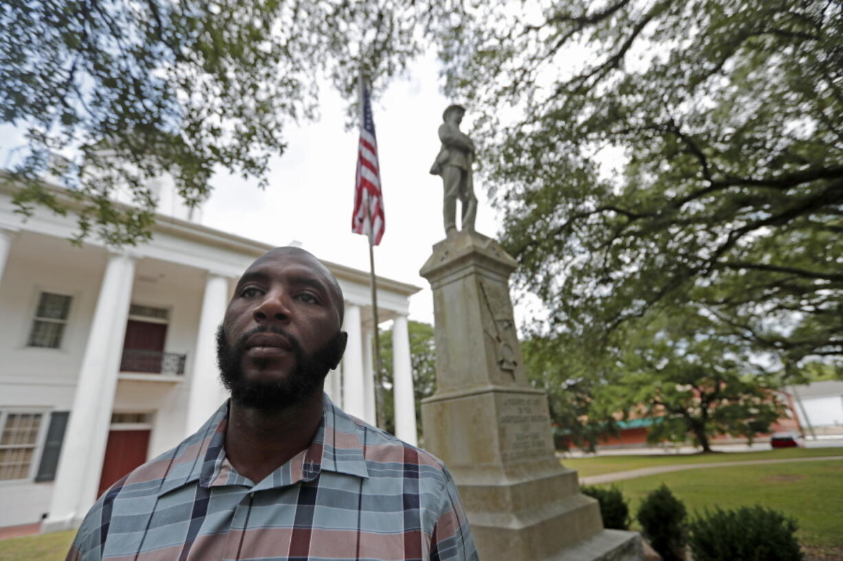 Ronnie Anderson, an African-American man charged with possession of a firearm by a convicted felon, poses for a photo in front of a confederate statue on the lawn of the East Feliciana Parish Courthouse, where he is facing the charge, in Clinton, La. The statue of the unnamed Confederate soldier has stood since 1909 in front of the courthouse in East Feliciana Parish, hands resting on his rifle looking down on the flow of lawyers, jurors and defendants going into the white columned building.