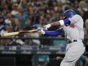 Los Angeles Dodgers’ Manny Machado hits a two-run home run during the seventh inning of the team’s baseball game against the Seattle Mariners, Friday, Aug. 17, 2018, in Seattle. It was Machado’s second home run of the game. (AP Photo/Ted S.