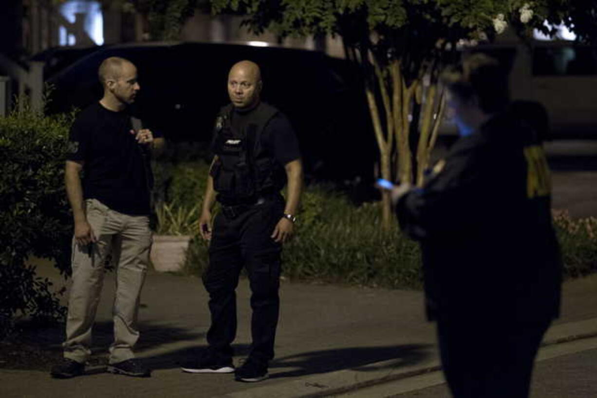 Agents with the Bureau of Alcohol, Tobacco, Firearms and Explosives stand outside the family home, in Baltimore, Sunday, Aug. 26, 2018, of the suspect in a mass shooting earlier in the day in Jacksonville, Fla.