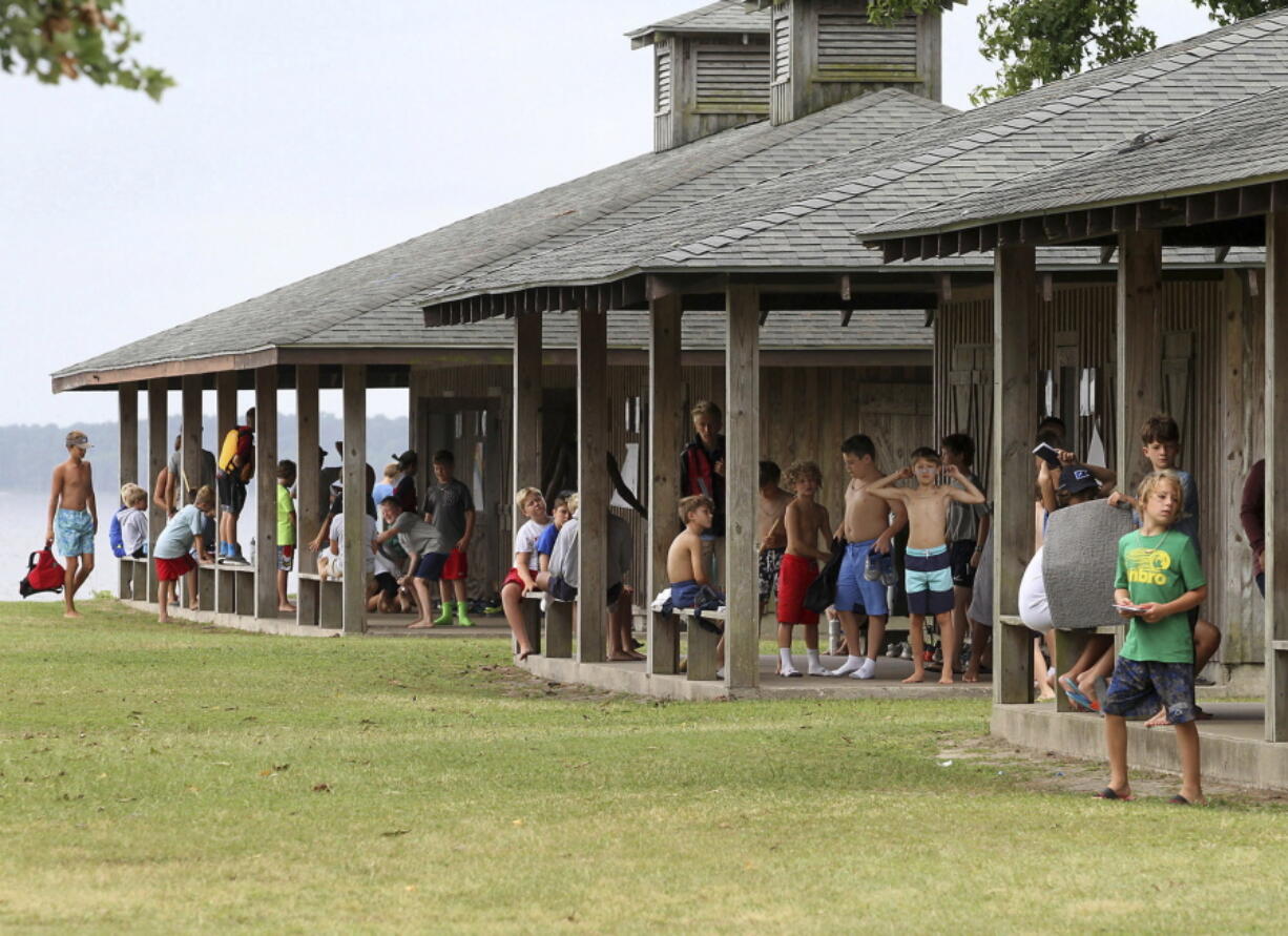 Children gather at cabins and get ready for the day’s activities during a four-week summer camp at Camp Sea Gull near Arapahoe, N.C. About 90 percent of the nearly 8,400 sleep-away camps counted by the American Camp Association are now device free.