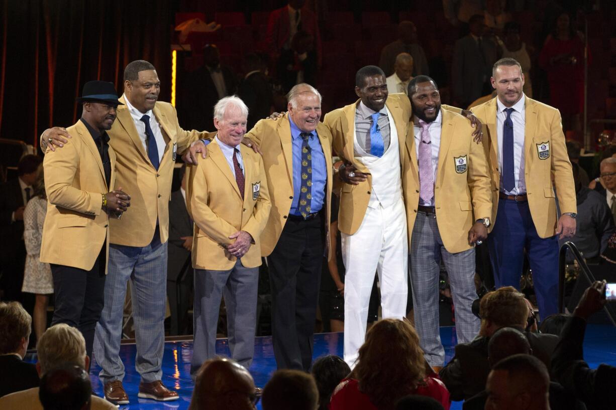 The 2018 Class of the Pro Football Hall of Fame poses during the Pro Football Hall of Fame Enshrinement Festival Enshrinee's Gold Jacket Dinner on Friday, Aug. 3, 2018, in Canton, Ohio. From left are Brian Dawkins, Robert Brazile, Bobby Beathard, Jerry Kramer, Randy Moss, Ray Lewis, and Brian Urlacher.