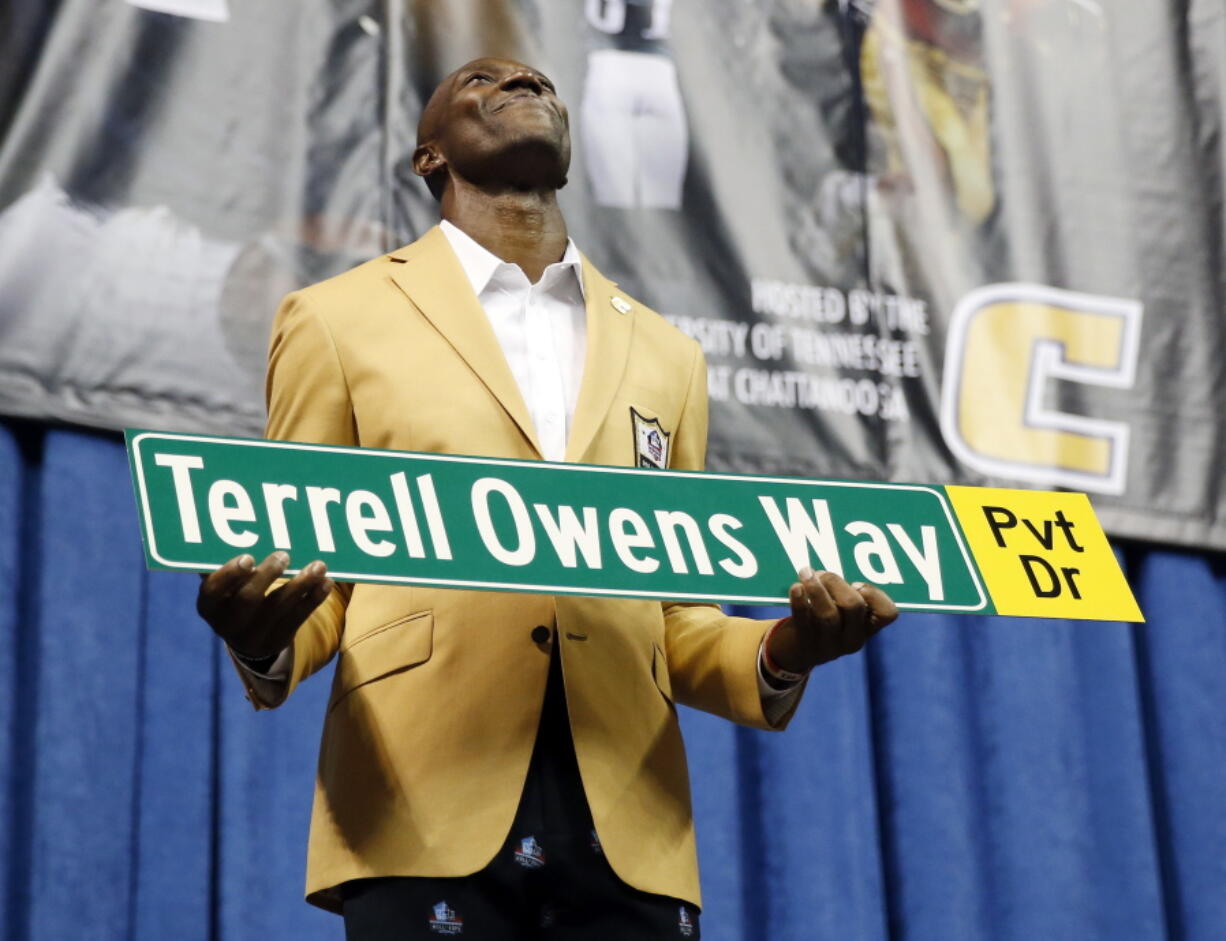 Former wide receiver Terrell Owens holds a street sign after a road was named for him following his Pro Football Hall of Fame speech, Saturday, Aug. 4, 2018, in Chattanooga, Tenn. Instead of speaking at the Hall of Fame events in Canton, Ohio, Owens celebrated his induction at the University of Tennessee at Chattanooga, where he played football and basketball and ran track.