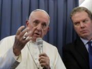 Pope Francis, flanked by Vatican spokesperson Greg Burke, listens to a journalist’s question during a press conference aboard of the flight to Rome at the end of his two-day visit to Ireland, Sunday, Aug. 26, 2018.