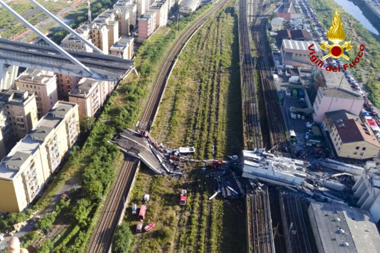 In this photo released by the Italian firefighters, rescue teams work among the rubble of the collapsed Morando highway bridge in Genoa, northern Italy, on Tuesday. A bridge on a main highway linking Italy with France collapsed in the Italian port city of Genoa during a sudden, violent storm, sending vehicles plunging 90 meters (nearly 300 feet) into a heap of rubble below.