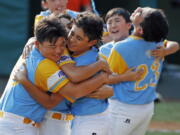 Honolulu, Hawaii pitcher Ka'olu Holt, center, begins to celebrate with Sean Yamaguchi , left, and Aukai Kea (23) after pitching a complete game, 3-0 shutout in the Little League World Series Championship baseball game against South Korea in South Williamsport, Pa., Sunday, Aug. 26, 2018. (AP Photo/Gene J. Puskar).