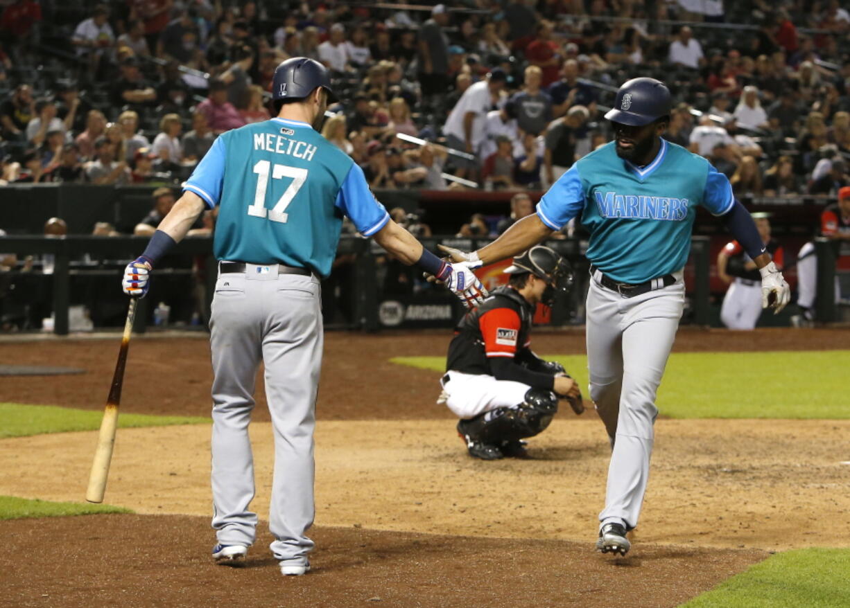 Seattle Mariners’ Denard Span celebrates with Mitch Haniger (17) after hitting a solo home run against the Arizona Diamondbacks during the 10th inning of a baseball game Saturday, Aug. 25, 2018, in Phoenix.